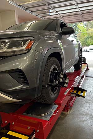 Grey sport utility vehicle being aligned on an alignment machine front view