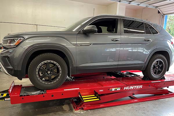 Grey sports utility vehicle being aligned on alignement machine side view