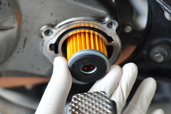 Hand in white glove Performing an Oil Filter Change