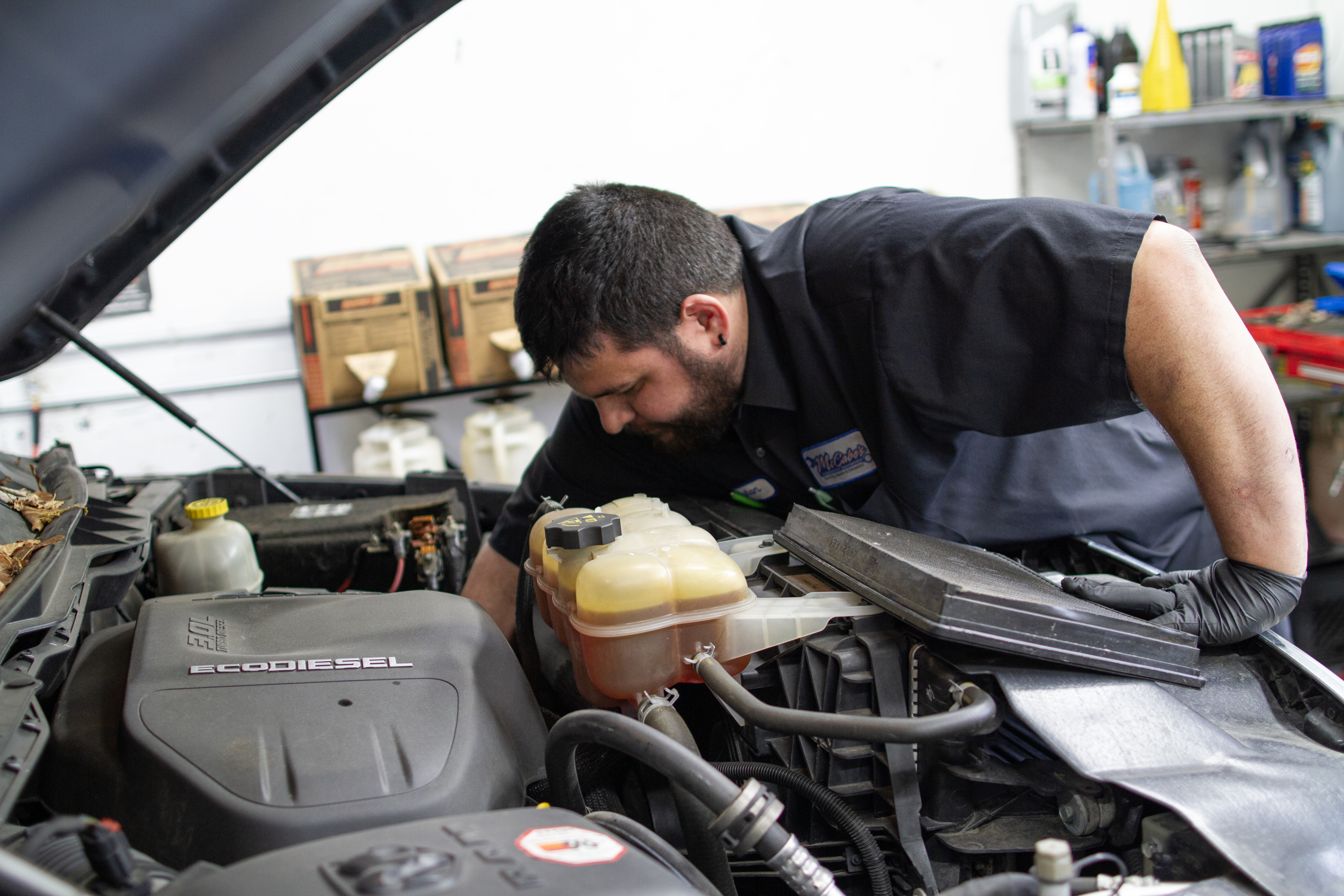 Heater and cooling system service McCabe’s technician working near the coolant reservoir under the hood